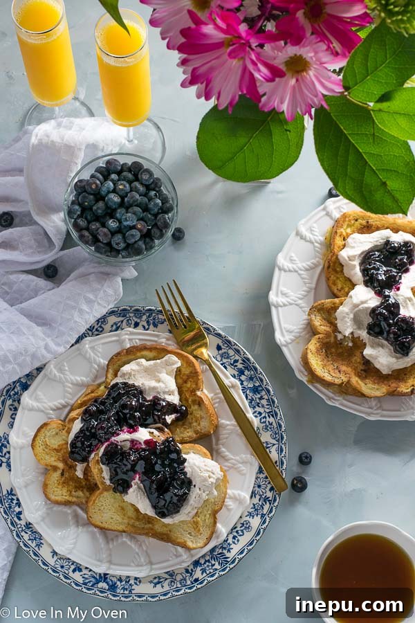Fancy Earl Grey French Toast on a plate with blueberry compote and whipped cream
