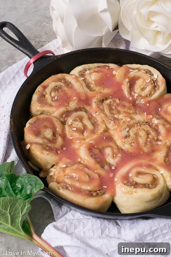 A top-down view of Rhubarb Streusel Rolls in a skillet, freshly glazed and ready to be served, highlighting their inviting appearance.