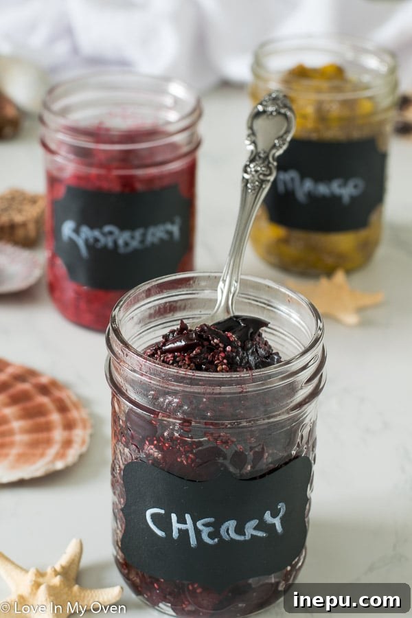 A spoon scooping up a portion of delicious 3-ingredient chia jam from a glass jar.