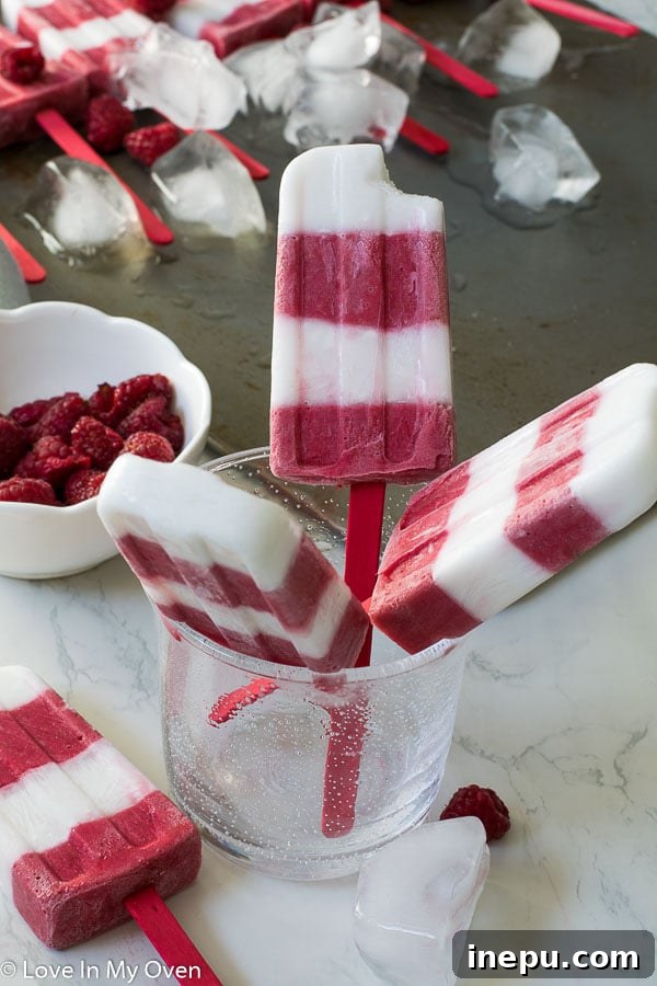 Raspberry Coconut Frozen Delights 5 Assortment of healthy raspberry coconut popsicles on a wooden board