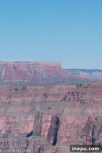 Another breathtaking view of the Grand Canyon, with a small helicopter visible in the distance.