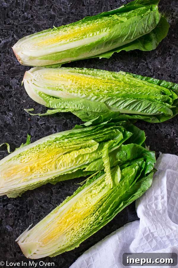 Smoky Romaine Caesar 4 Close-up of three grilled romaine hearts laid out on a serving platter, showing perfect char marks