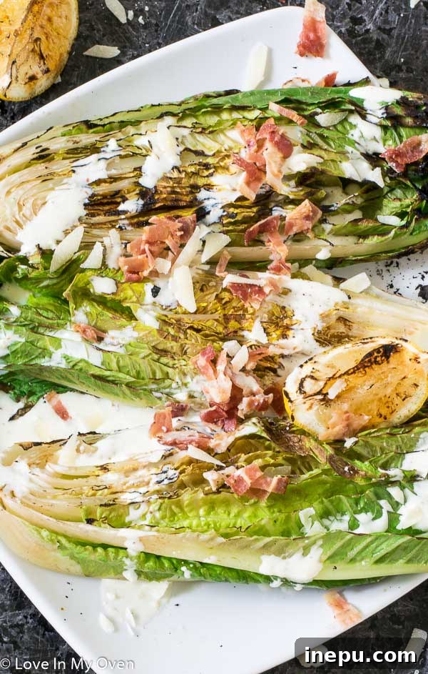 Smoky Romaine Caesar 6 A large bowl of grilled romaine Caesar salad, generously topped with dressing, bacon, and parmesan, ready for serving