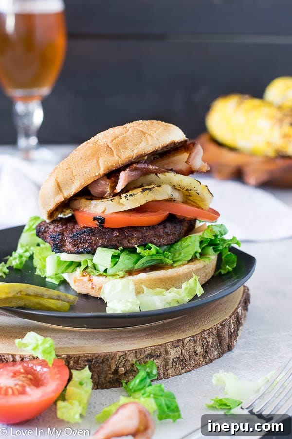 Kona Aloha Burger 4 Assembled Kona Burger on a plate with a pickle