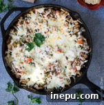 A small image of Queso Fundido with Chorizo in a cast iron skillet.