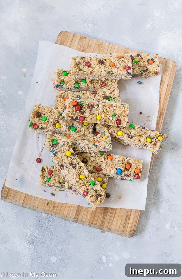 Chewy homemade M&M granola bars stacked, showcasing their colorful appeal and perfect texture. An ideal nut-free snack for all ages.