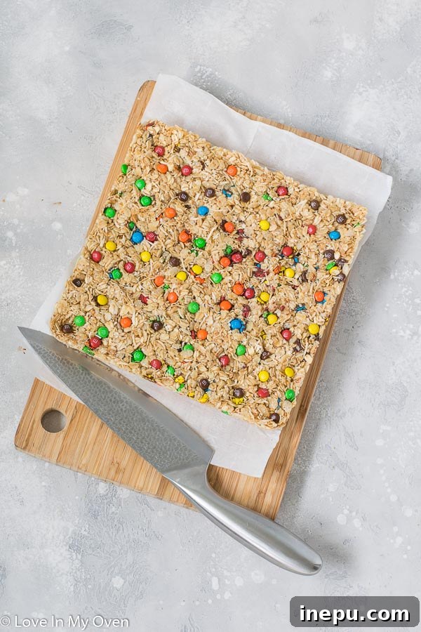 Perfectly sliced M&M granola bars arranged on a wooden cutting board, ready for serving or packing.