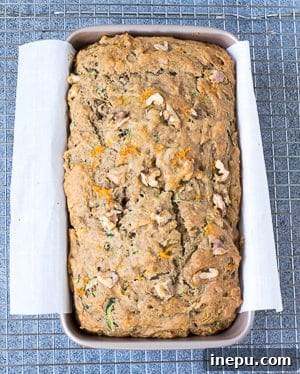 A whole loaf of Orange Zucchini Bread cooling on a wire rack
