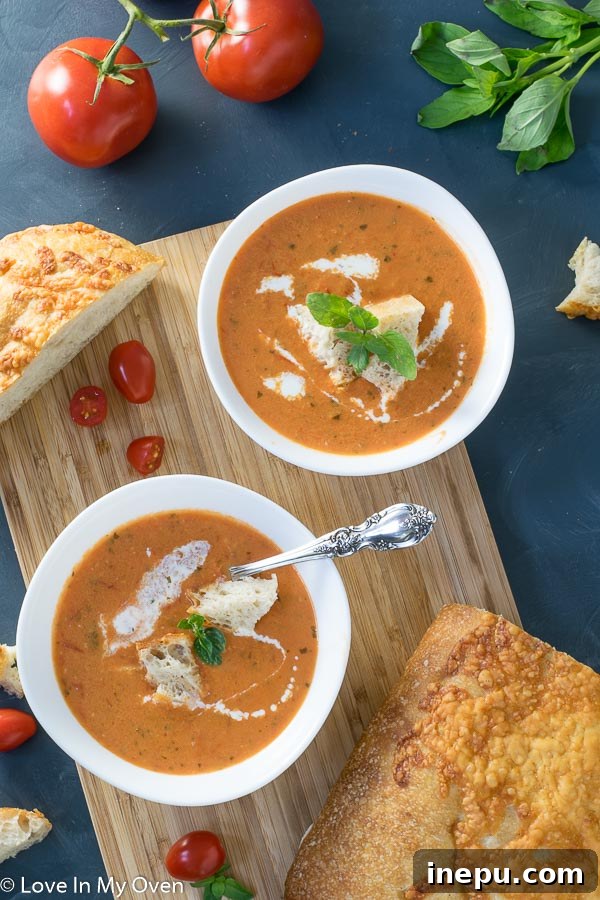 Sun-Kissed Tomato Basil Bisque 6 Two bowls of creamy roasted tomato basil soup with bread for dipping