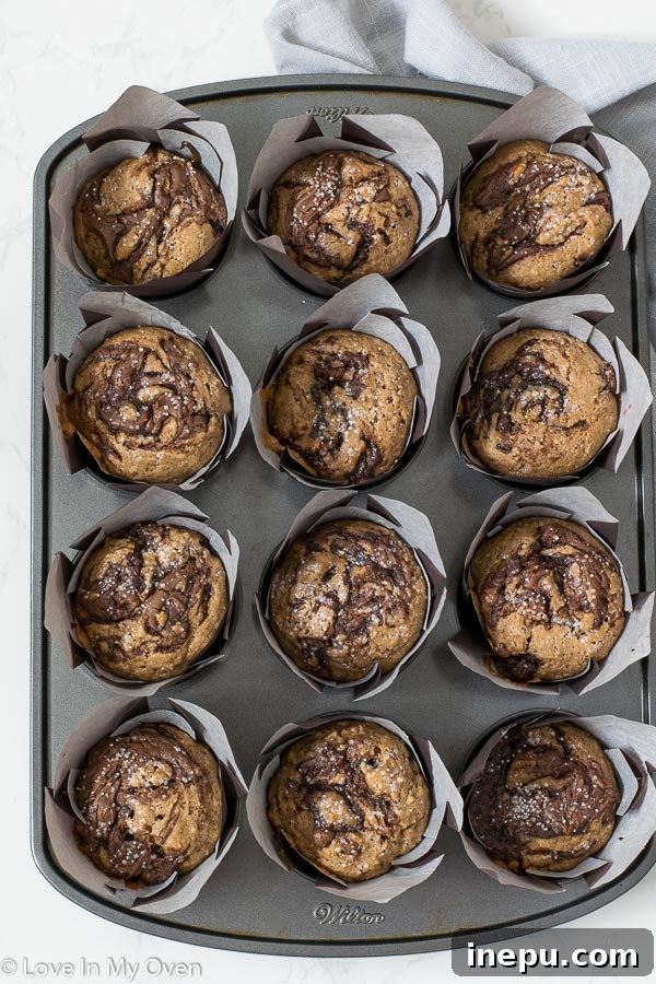 Deliciously swirled cinnamon Nutella muffins baked to perfection, garnished with sparkling sugar.