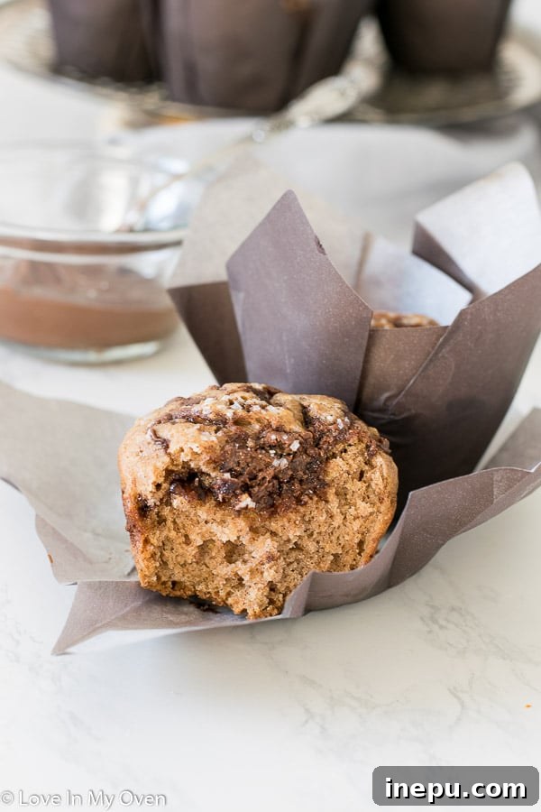 A close-up view of the interior of a sliced Nutella muffin, showcasing the beautiful swirl pattern and moist texture.