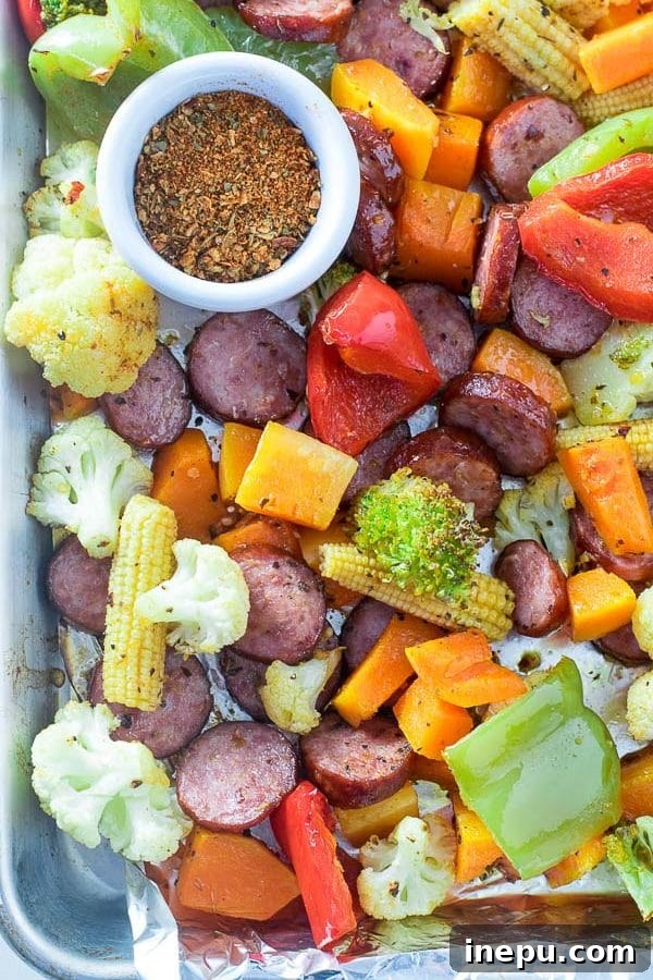 Portion of the roasted sausage and vegetable dish served in a bowl, showing the vibrant colors.