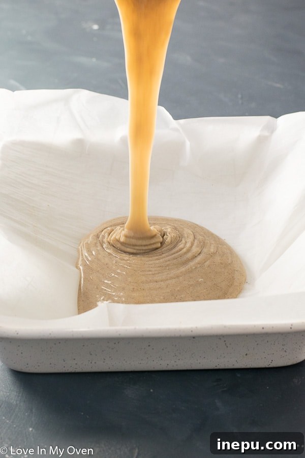 Freshly poured gingerbread fudge in an 8x8 pan, ready for chilling and setting