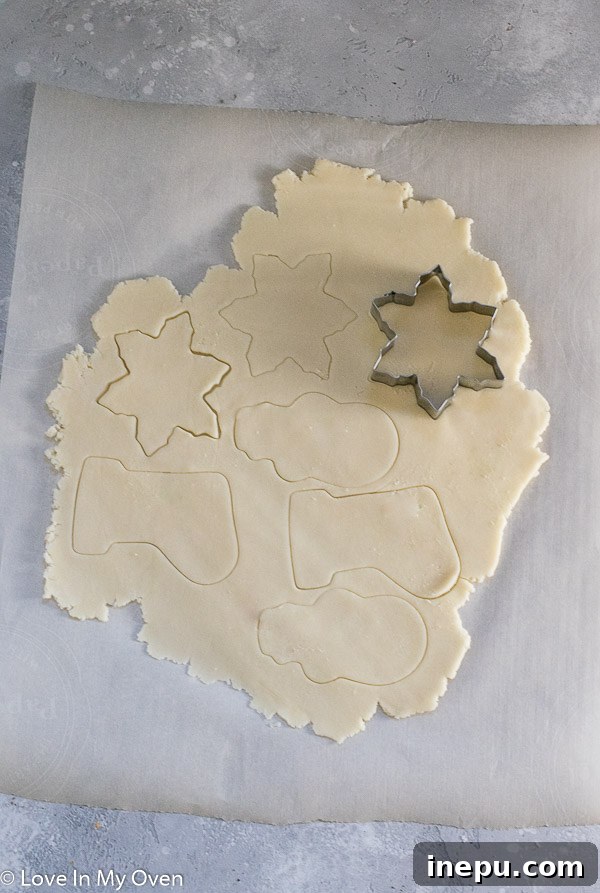 shortbread cookie dough being rolled between parchment paper