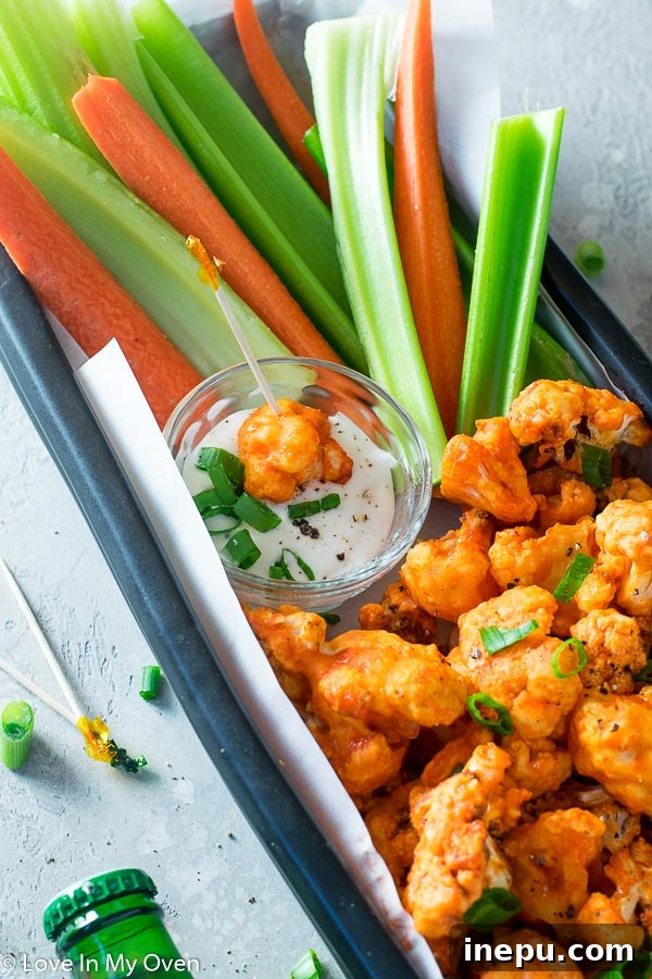 Crispy Air Fryer Buffalo Cauliflower Wings 7 A vibrant platter of Air Fryer Buffalo Cauliflower served with ranch dip and celery sticks.