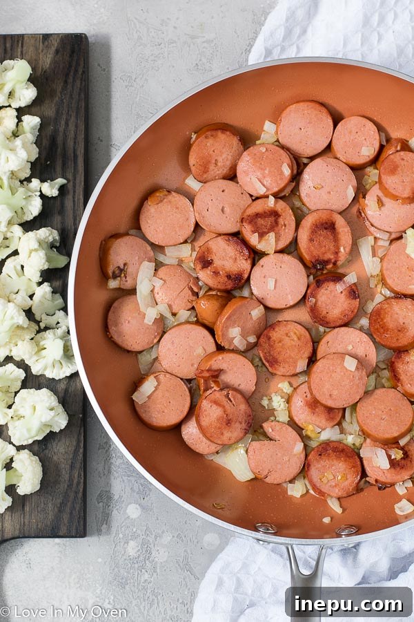 sausage, onion, and garlic sautéing in a skillet
