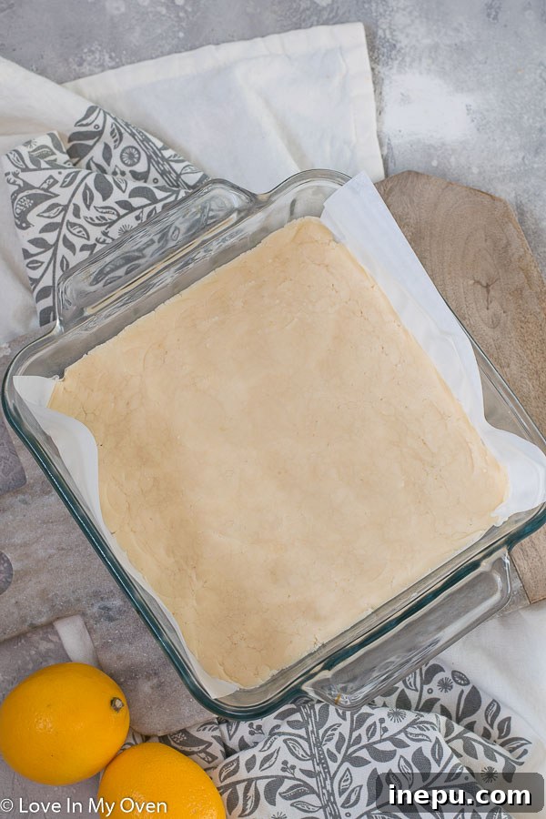 Bright Meyer Lemon Dream Bars 4 Ingredients for the Meyer lemon bars shortbread crust on a baking sheet.
