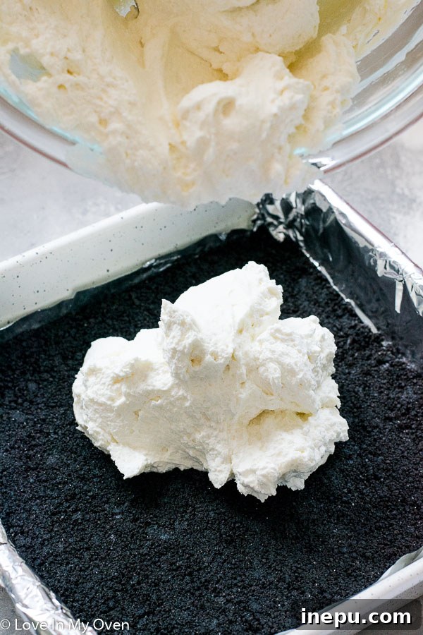 Cheesecake filling being smoothed into crust