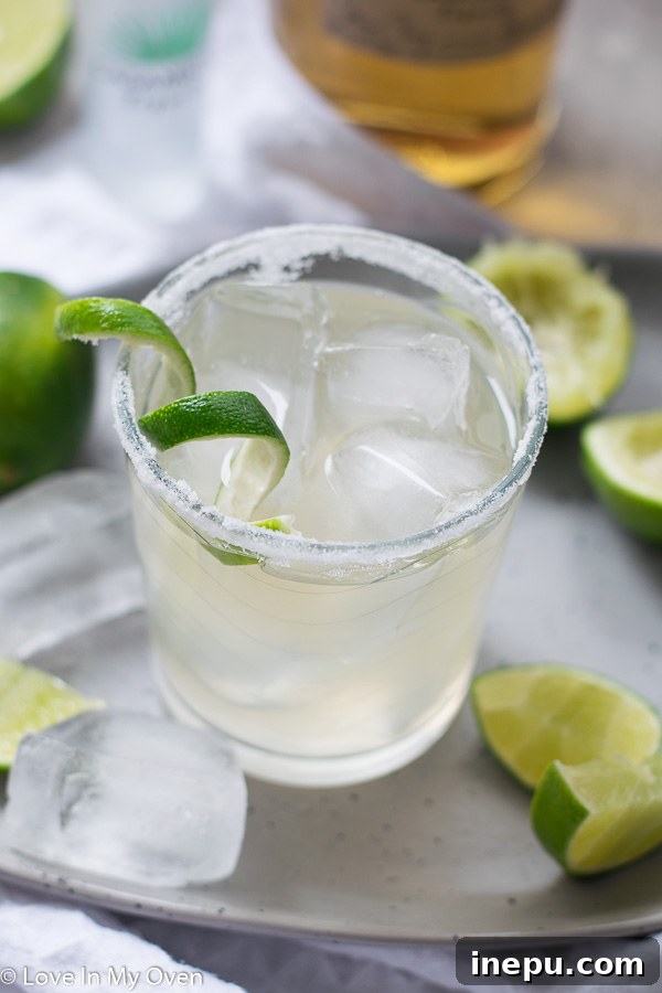 The Essential Margarita 2 Classic simple margarita served in a salt-rimmed glass with lime wedge