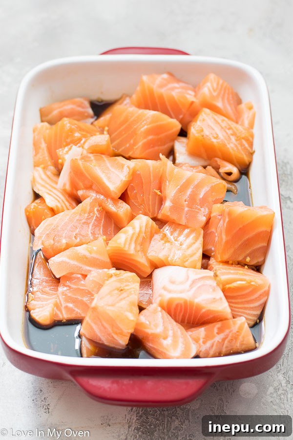 Marinating salmon cubes in homemade teriyaki sauce