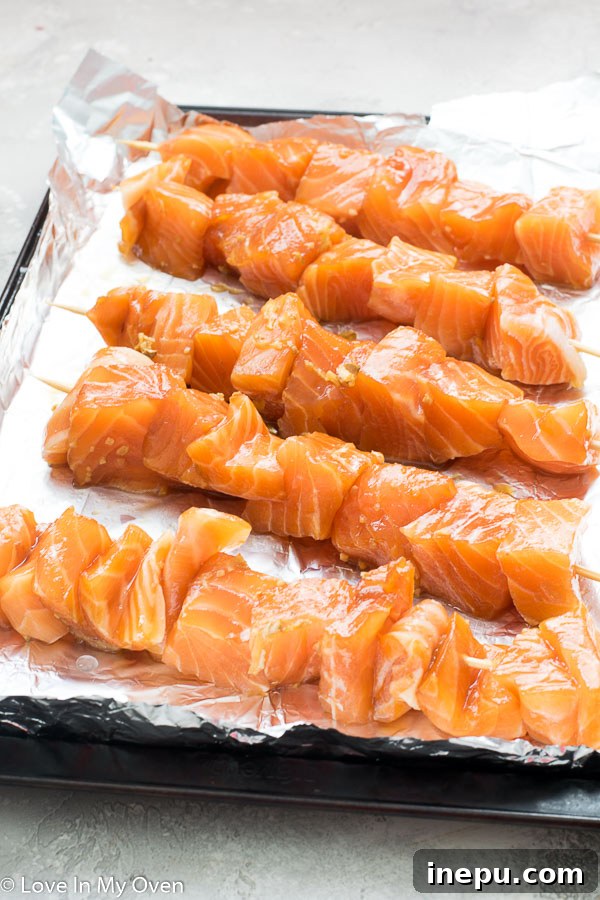 Assembling teriyaki salmon onto wooden skewers