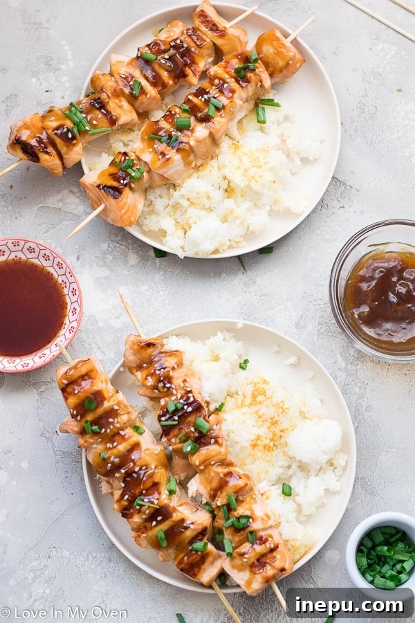 Teriyaki salmon bites garnished with fresh herbs and served with crispy rice