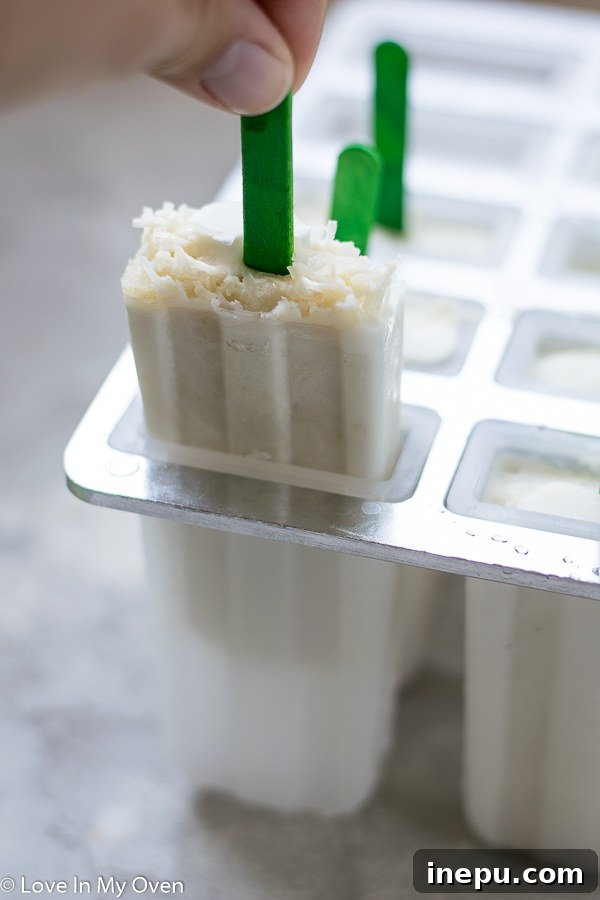 Zesty Coconut Lime Bliss 5 Coconut lime popsicles being prepared with an optional shredded coconut topping.