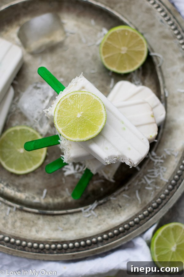 Zesty Coconut Lime Bliss 6 Close-up of a single coconut lime popsicle with visible shredded coconut topping.