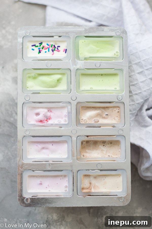 Popsicle molds filled with ice cream, with sticks inserted, awaiting their final deep freeze