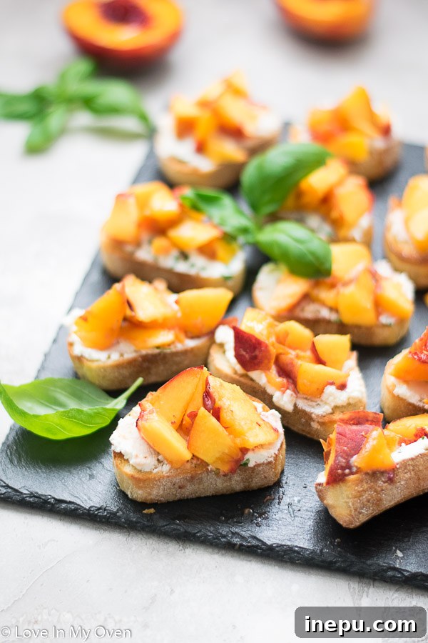 Various grilled peach crostini stacked on a white plate