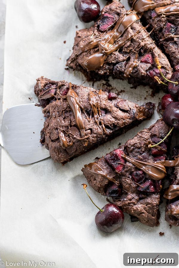 Decadent Chocolate Cherry Scones 6 Freshly baked chocolate cherry scones with melted chocolate drizzle on a cooling rack