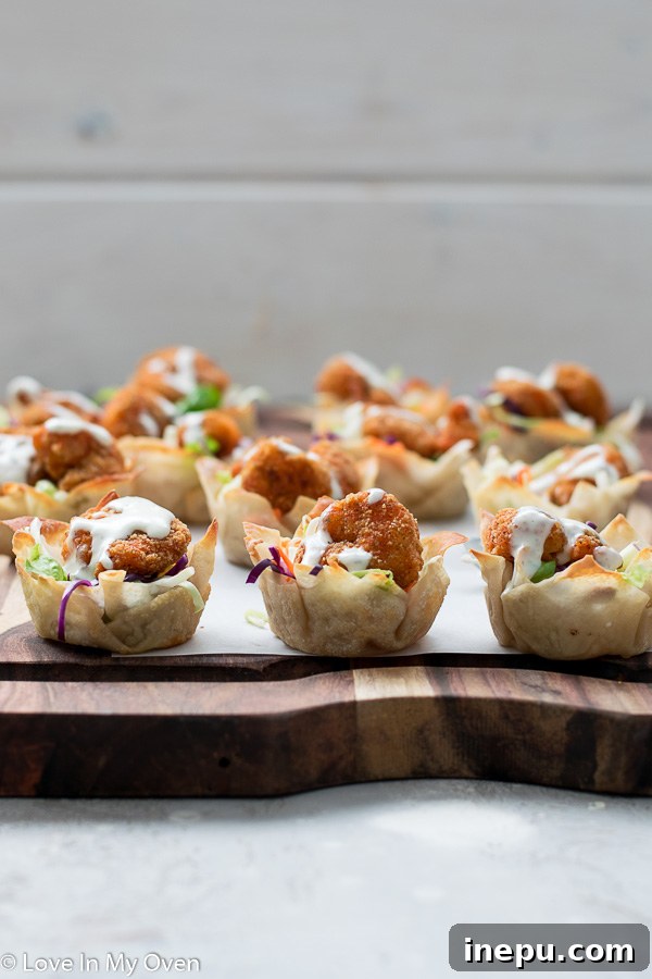 Several Buffalo Shrimp Wonton Cups on a serving tray, garnished and ready for guests.