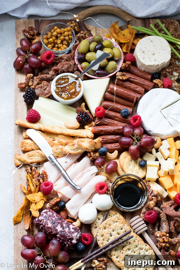 Gobble & Graze Board 3 Close-up of a vibrant turkey charcuterie board featuring turkey deli slices, various cheeses, grapes, and crackers