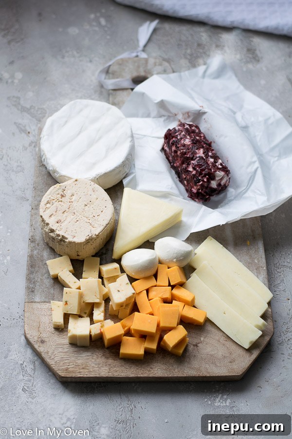 Gobble & Graze Board 4 Assortment of cheeses on a charcuterie board, including cubed cheddar, brie, and goat cheese