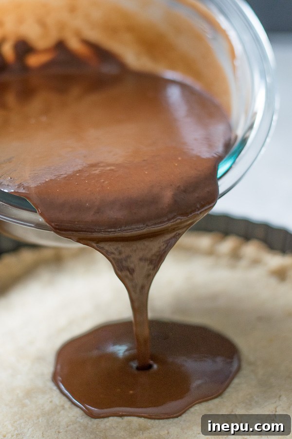 Decadent Grain Free Peppermint Chocolate Tart 6 Pouring the peppermint chocolate filling into tart crust
