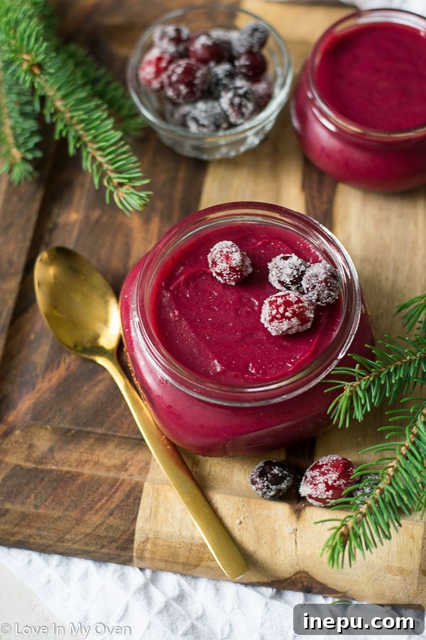 Cranberry curd served in a jar with a spoon.