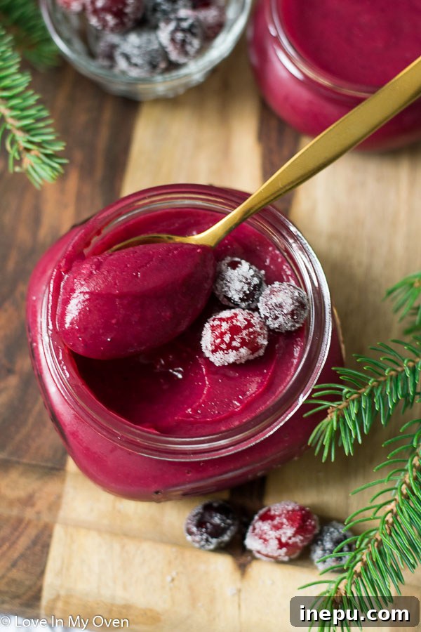 Two jars of cranberry curd on a wooden surface.