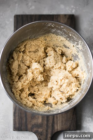 Hands demonstrating how to stuff caramel into cookie dough