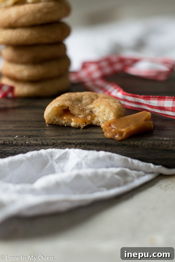 Decadent Caramel Snickerdoodles 10 Stack of caramel snickerdoodles, with one cut in half to show the caramel inside