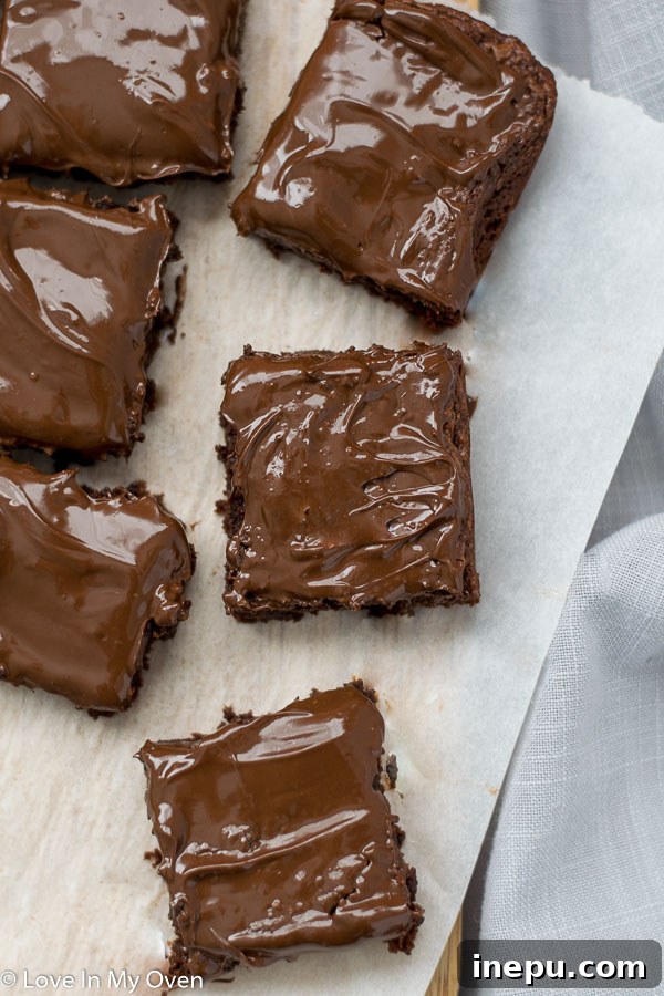 Effortless 3-Ingredient Nutella Brownies 8 A slice of frosted Nutella brownie with a bite taken out, showing the fudgy interior.