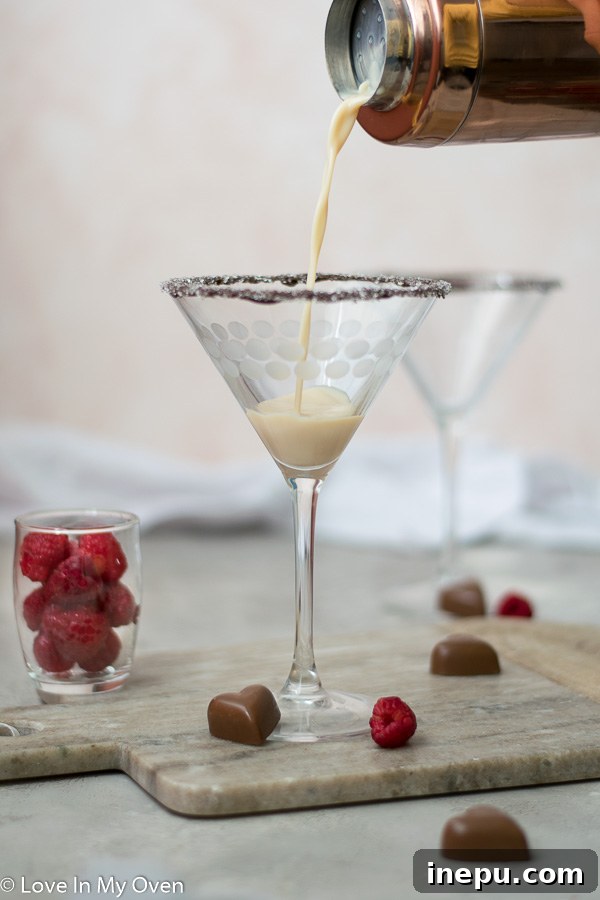 Midnight Chocolate Martini 4 Two chocolate vodka martinis in elegant glasses, garnished with shaved chocolate, on a dark surface.