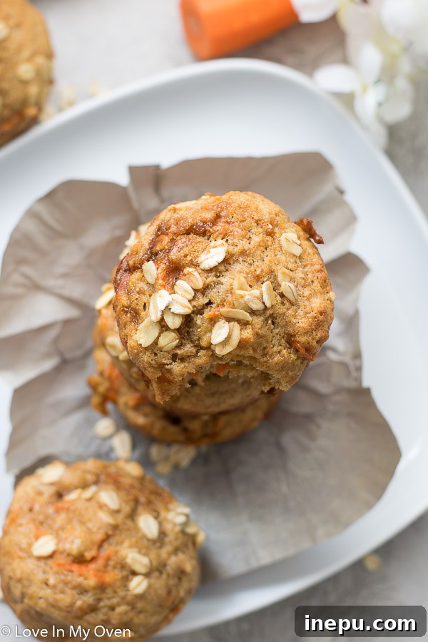 Sunshine Carrot Banana Muffins 3 Close-up of fluffy, golden-brown healthy banana carrot muffins, showcasing their inviting texture.