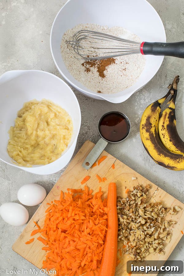 Sunshine Carrot Banana Muffins 4 Bowls of prepped ingredients for healthy banana carrot muffins: flour, mashed banana, shredded carrots, and walnuts.