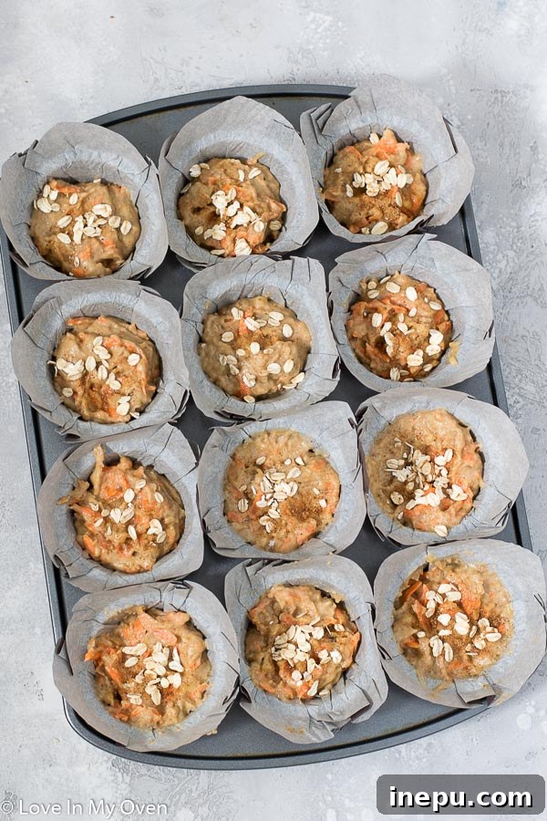 Sunshine Carrot Banana Muffins 6 A close-up of a healthy banana carrot muffin, showing its moist interior and golden crust.