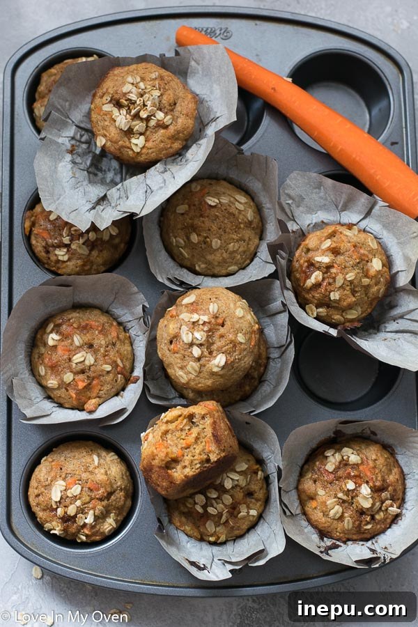 Sunshine Carrot Banana Muffins 7 A stack of healthy banana carrot muffins on a wooden board, ready to be enjoyed.