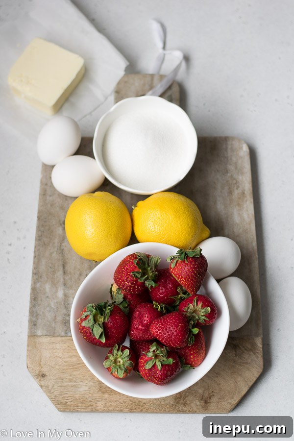 Luscious Strawberry Lemon Curd 4 Fresh strawberries, lemons, sugar, eggs, and butter laid out on a table, ready for strawberry lemon curd preparation.
