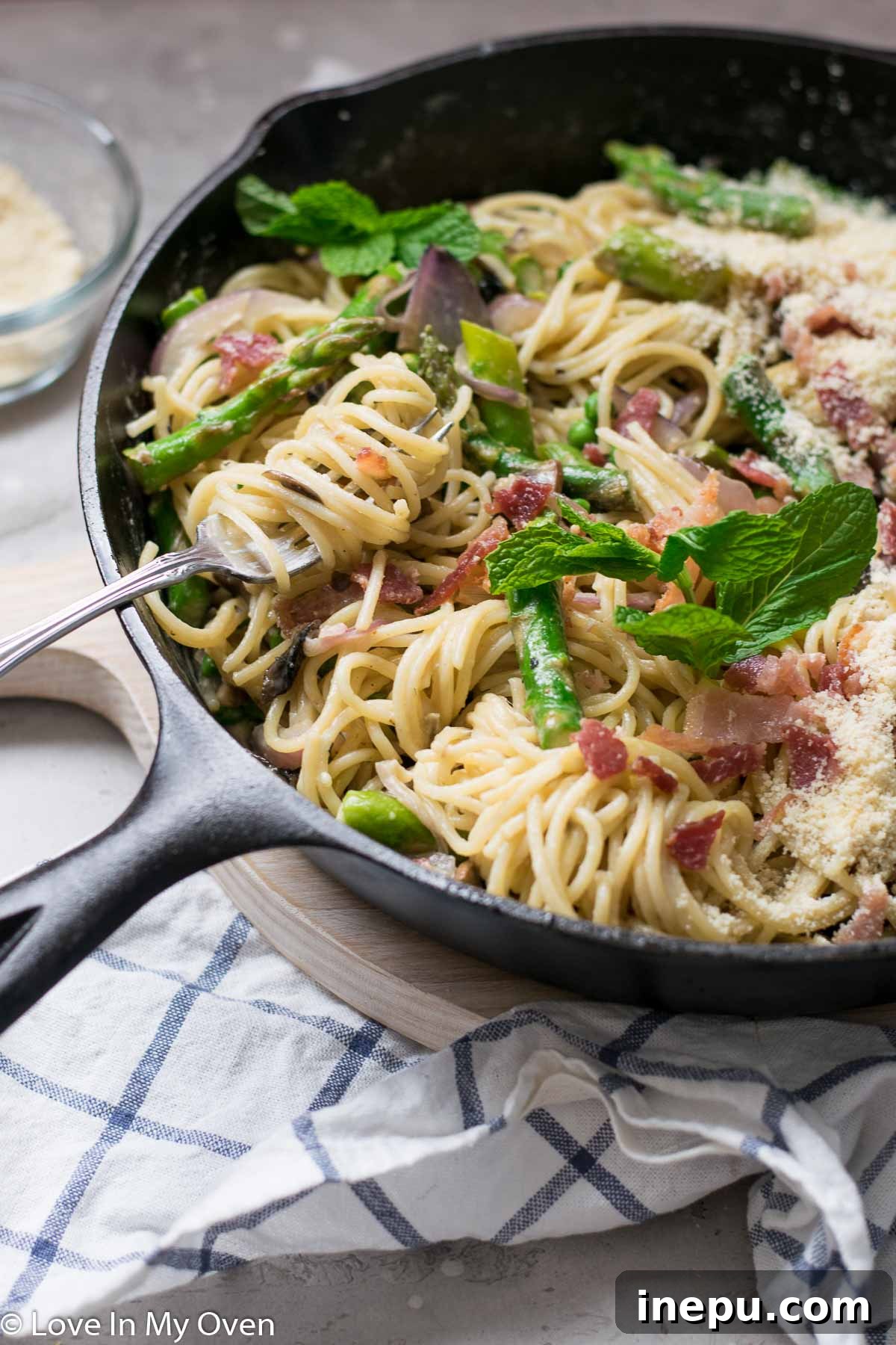 Springtime Carbonara with Asparagus and Peas 8 Overhead shot of spaghetti carbonara in a bowl, with spring vegetables and parmesan
