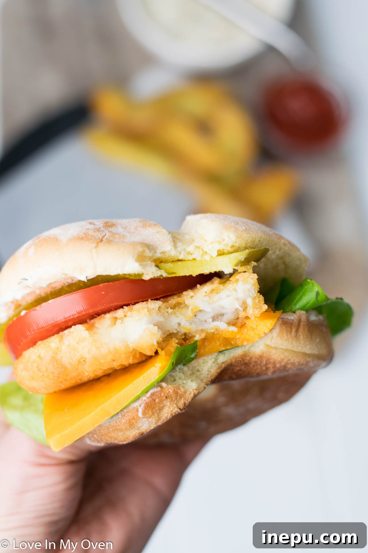 Assembled crispy fish burger with aioli and toppings
