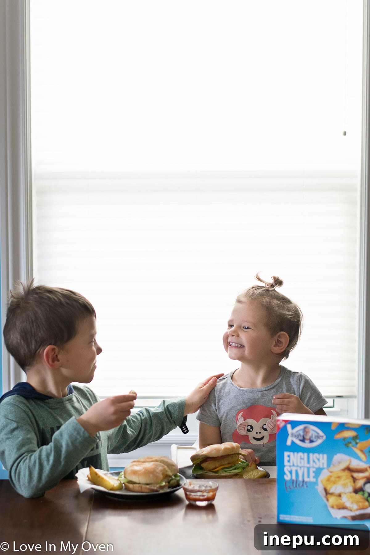 Family enjoying crispy fish burgers and potato wedges