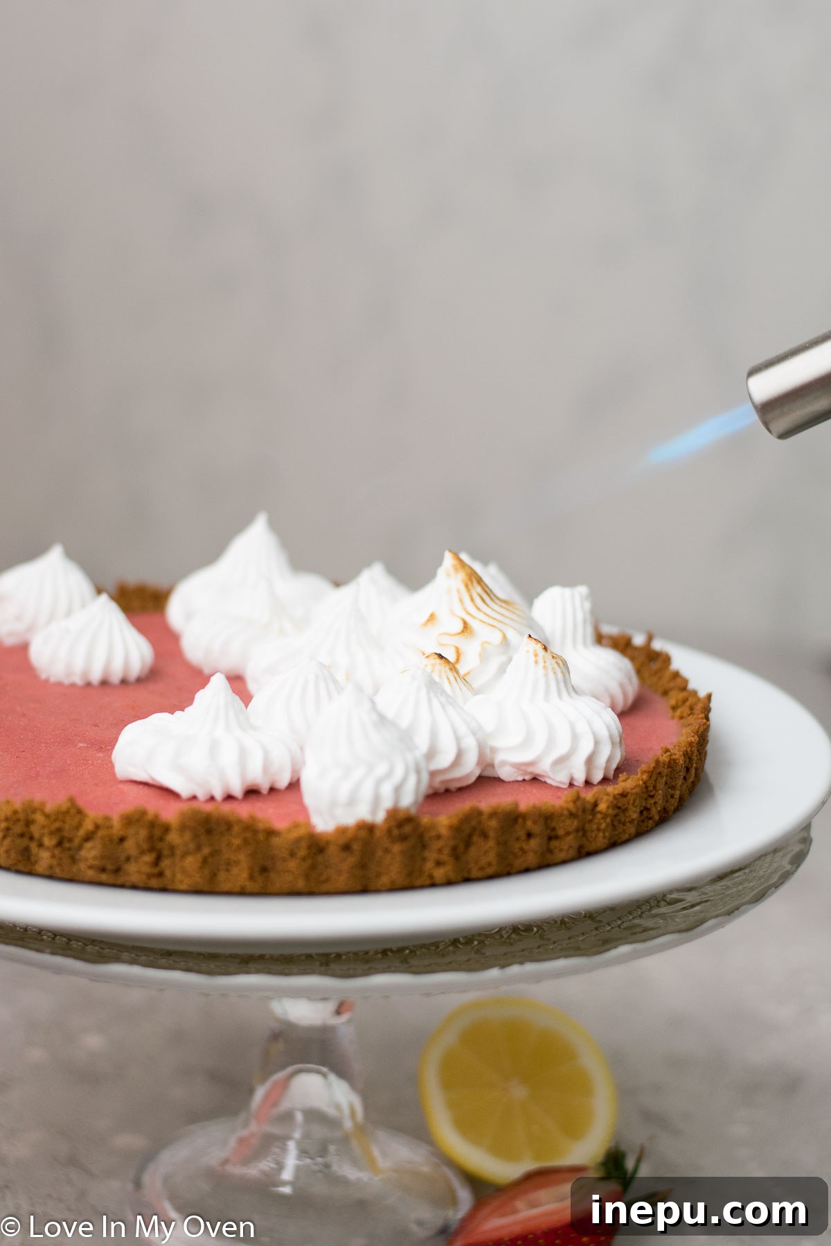 Toasting Meringue on a Strawberry Lemon Curd Tart with a Kitchen Torch